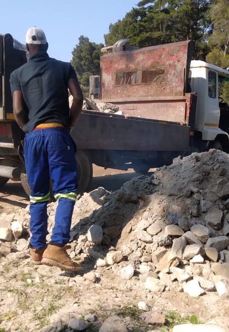 Tipper truck loading building debris on a residential site